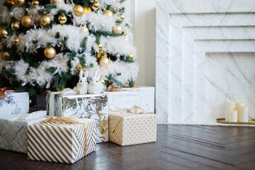 Big beautiful New Year tree with gifts in a white decorated hall for the New Year