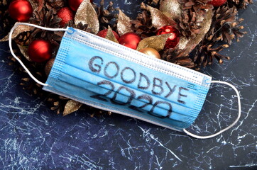 Protective blue face mask on Advent wreath. Text on the mask Goodbye 2020, Covid-19 concept