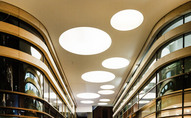 Modern ceiling lighting with round recessed lamps shopping arcade. Lighting for halls, offices and large buildings - obrazy, fototapety, plakaty