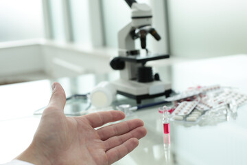 Doctor's hand points to the table with medicines