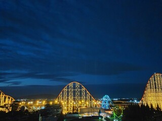 Fototapeta premium 夜空を背景にしたライトアップされた遊園地のジェットコースター