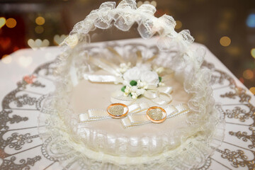 Fototapeta na wymiar Gold wedding rings on a lace basket. Marriage.