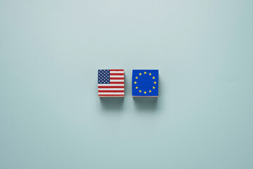 USA and Euro flag print screen on wooden block cubes with blue background. It is symbol of economic...