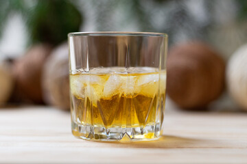 glass of gold rum with ice on wooden table