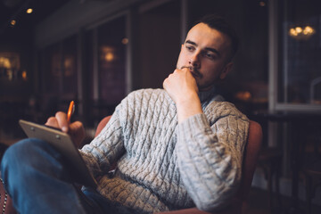 Fototapeta premium Thoughtful man writing information on clipboard