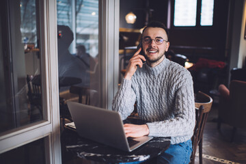 Happy man talking on smartphone in cafe