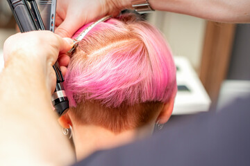 Fototapeta premium Hairdresser pinches hair with the clip before doing hairstyle in a hair salon