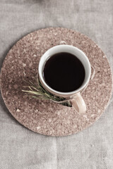 A cup of black coffee on sackcloth background decorated with Christmas tree branch top view. Winter morning in rustic style. Flatlay. Copy space