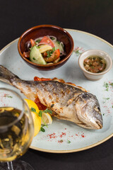 Whole Trout Fried in Pan and Served with vegetables and glass of white wine