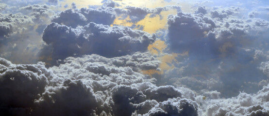 Aerial view of clouds and sky. Bird eye view from airplane window. Clouds panorama from airplane