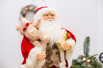 Santa claus decorating christmas tree on the white background