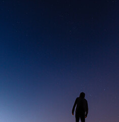 Fototapeta na wymiar Silhouette of a person looking at the sky full of stars