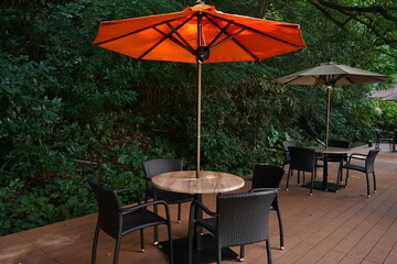 Fototapeta na wymiar Cafe Restaurant Terrace with large red parasol, 外のテラス席の椅子とテーブル