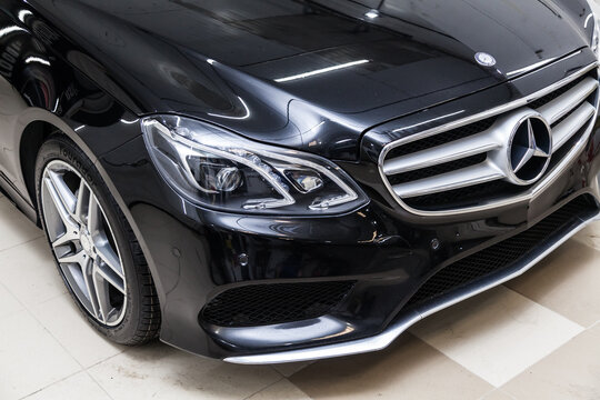 Close-up on a car Mercedes E-class body standing inthe garage box for polishing and removing scratches from the surface. Auto service industry.