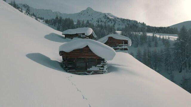 Aerial footage of snowy mountain huts in the South Tyrolean mountains. Italian Alps.