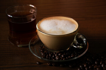 Hot coffee and hot tea on the floor of a wooden table.