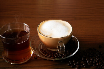 Hot coffee and hot tea on the floor of a wooden table.
