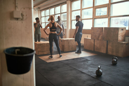 Diverse people doing box jumps during a gym workout