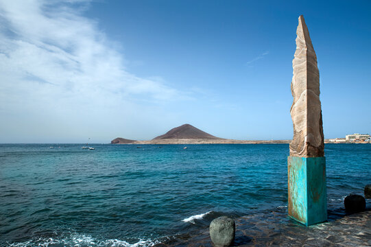 An obelisk made of volcanic rock in El Medano, monument of sharp cut lava with molted rock visible through situated on a promenade at one end of the picturesque town in Tenerife, Canary Islands, Spain