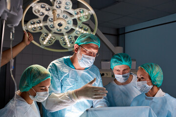 team of confident caucasian doctors and assistants take childbirth, delegate actions. friendly fast...