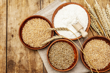 Ingredients for baking bread: wheat ears and a bowls of flour and grains