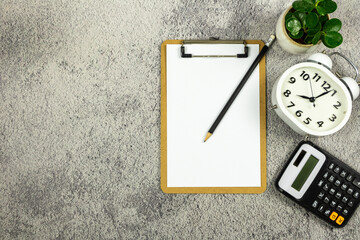 Clipboard and white paper with calculator on white office desk background. Flat lay design.