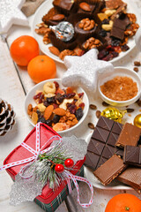 sweet food top view background for merry christmas or new year holiday decoration - chocolate candies, tangerines, cookies on white wood