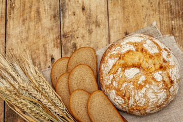 Fresh baked bread with wheat ears and slices