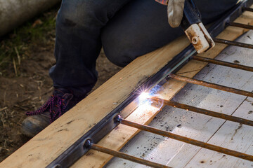 A man welds a metal frame to build an aviary, welding metal close up.