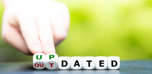 Hand turns dice and changes the word outdated to updated.
