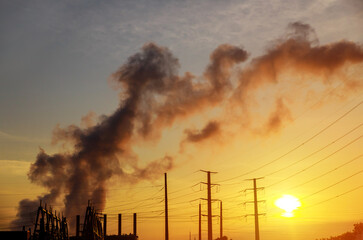 Factory pipe polluting air at dusk, the thermal power plants with during sunrise