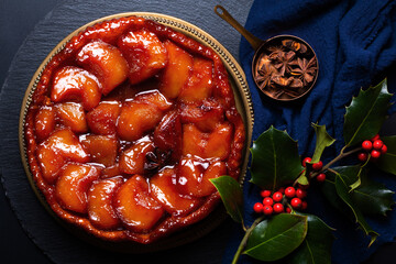 French Food concept homemade Upside down Apple caramel pie Tarte Tatin aux pomme on black slate...