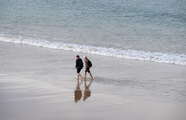 retirees enjoying a walk on the beach