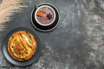 Delicious pancakes with chocolate and a cup of cinammon tea on gray background