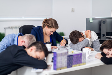 Working overtime to finish a project on time. A young architect at work while her tired colleagues having a break.