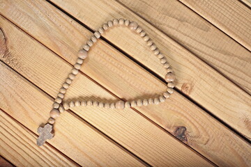 wooden rosary on wooden background