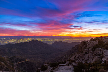 Tucson Arizona as seen from above with the colors of sunset in the distance and mountains.