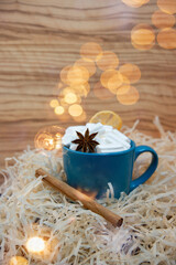 Fototapeta na wymiar White marshmallow in a green mug with star anise and cinnamon, glare from sparkles, romantic blur.