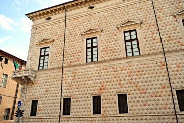 Fototapeta na wymiar details of the external facade of the Palazzo dei Diamanti in Renaissance style located in the historic center of Ferrara in Italy. Its main feature is the diamond-shaped masonry