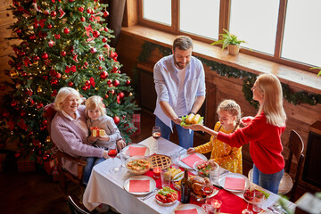 family preparing christmas table together, spend time together at home on the eve of New Year 2021, going to celebrate. top view