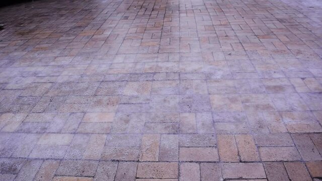 Pedestrian's feet walk cautiously along the sidewalk covered with slippery ice. Winter weather is surprising. The sharp drop in temperature froze the raindrops, covering everything with slippery ice.