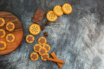 half view of cookies on wooden platter and crescent-shaped layout cookies on grey background