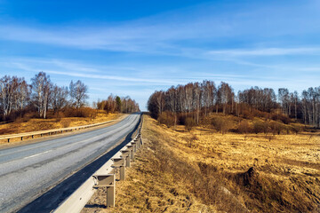 Asphalt road going through the countryside going into the distance.