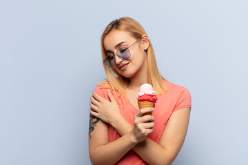 young blonde woman feeling in love, smiling, cuddling and hugging self, staying single, being...