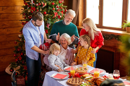 Portrait Of Extended Happy Family Posing At Camera Behind Table, They Have Fun And Meal Together, Celebration Concept