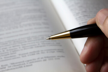 hand holding pen for writing on paper