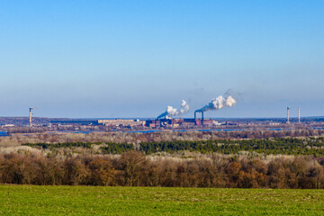 View on smoke pipes of the factory and agricultural field