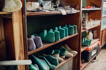 Colorful blanks for shoes are on the shelves in the cabinet in the shoe production studio.