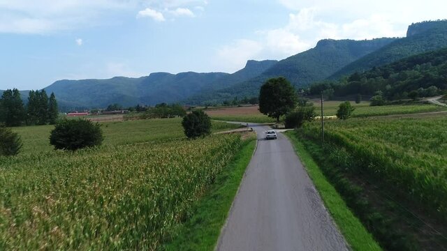 Aerial tracking shot of BMW e30 car on countryside road