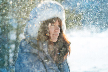 Woman surrounded by snowflakes at winter time, close up.